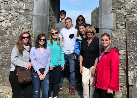 UConn students and faculty posed in a cobblestone entryway abroad.