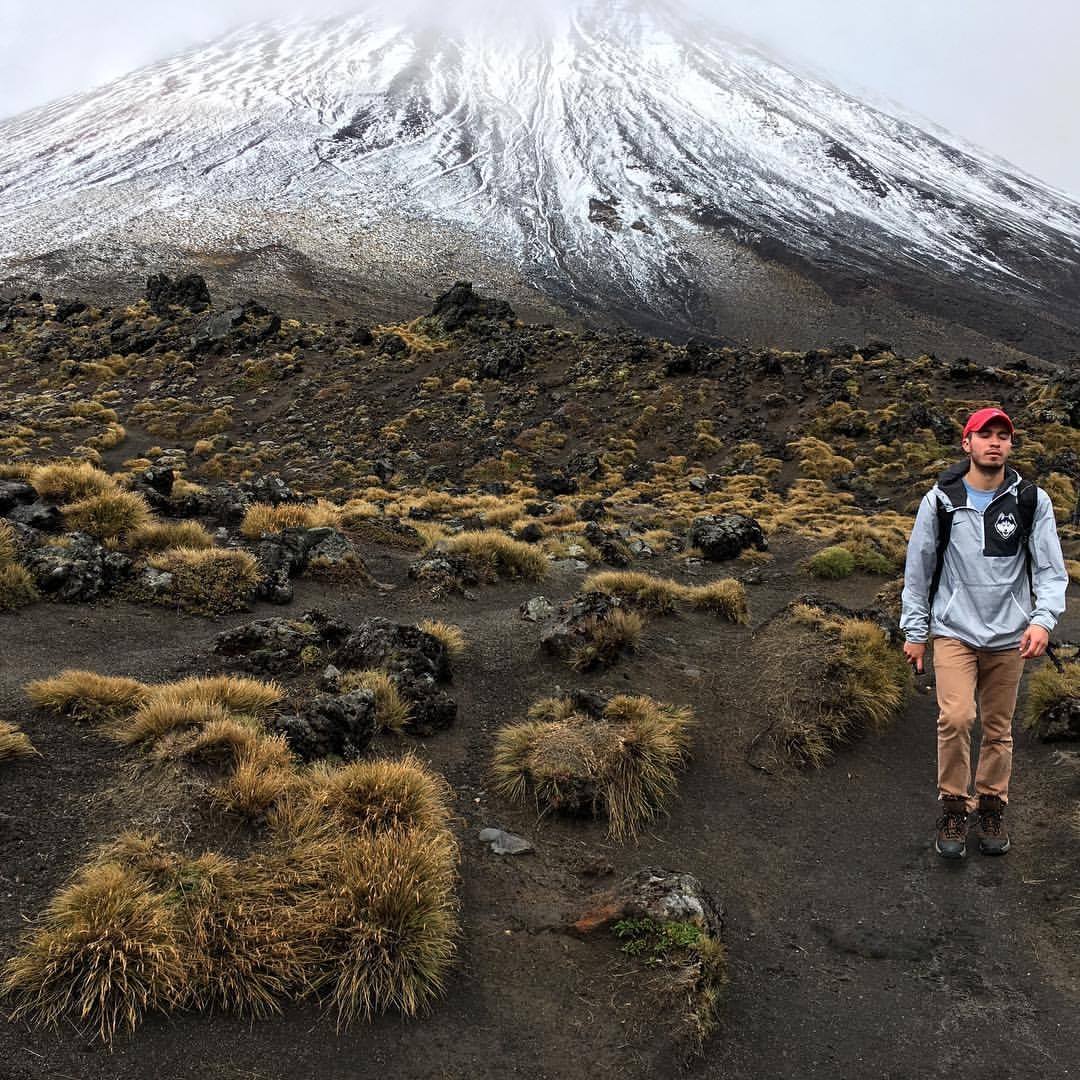 UConn student walking down a snowy mountain in New Zealand.