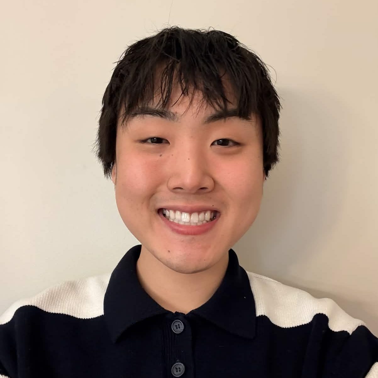 Male student photo wearing a collared shirt with thick white and navy stripes
